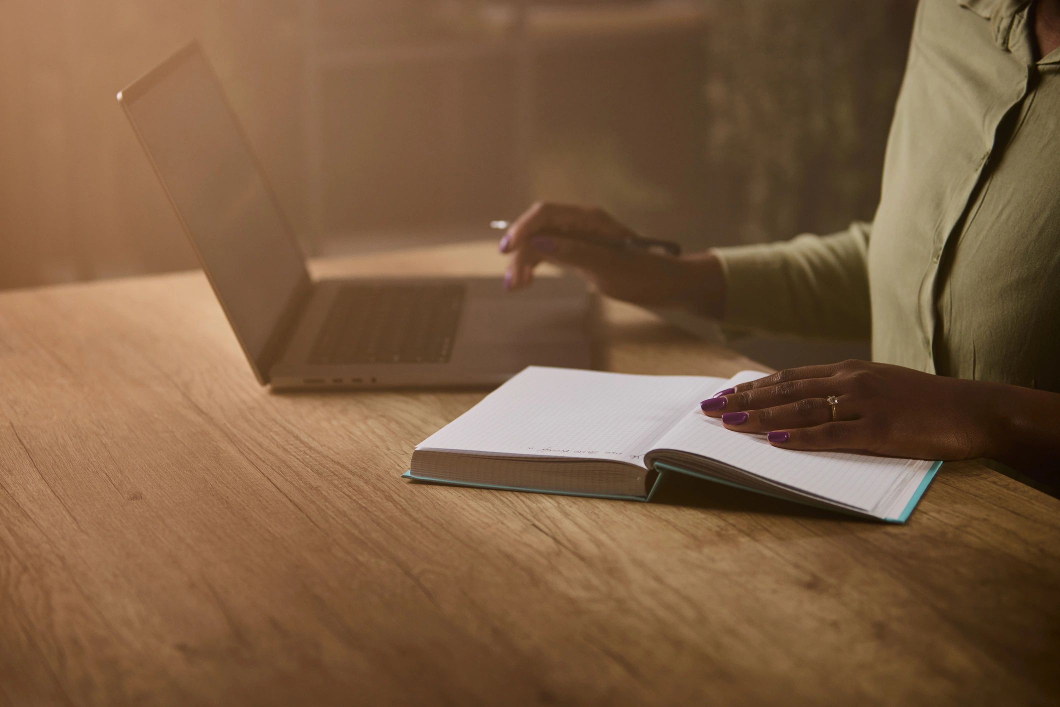 Creative workspace with notebook and laptop in soft light